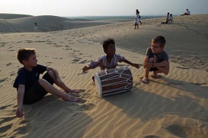 Indian boy playing drums in the Rajasthan desert near Jaiselmer