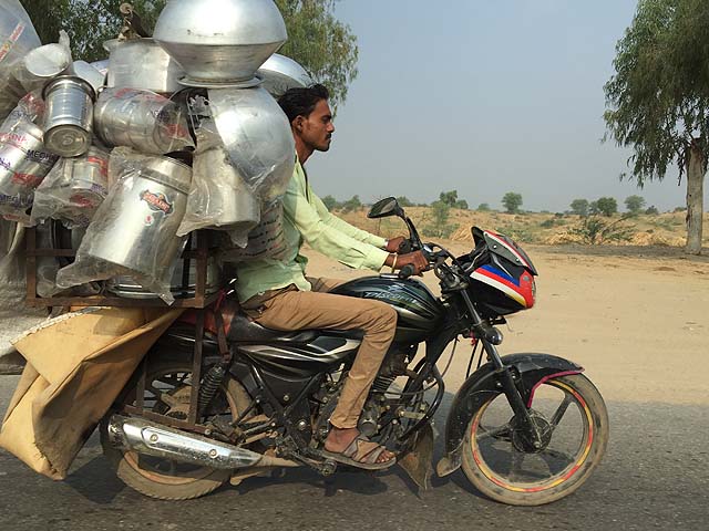 Indian man riding a fully laden motorbike